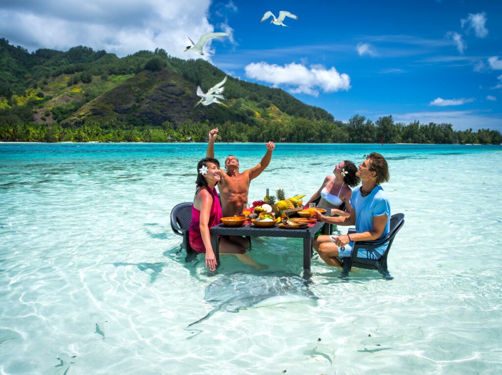 Dos parejas desayunando en el agua de la isla de polinesia con WAYAO